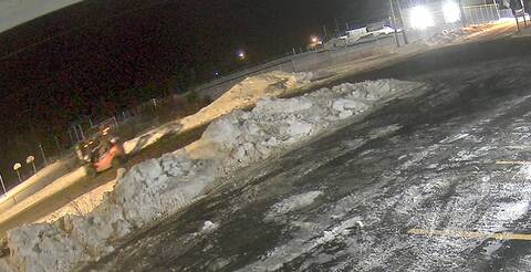 A still from a surveillance video, of a break and enter and theft suspect driving down a roadway in a forklift.