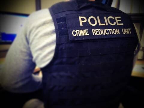 C.R.U. unit patch on the back of an officer's vest