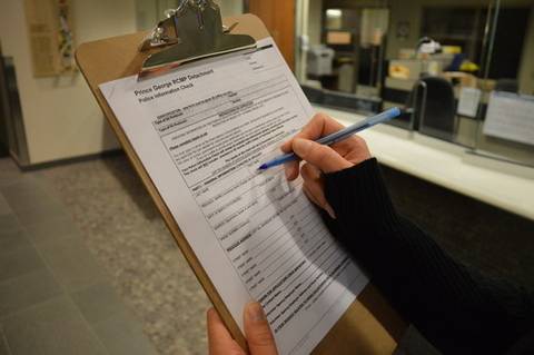someone about to fill out a Police Information Check on a clipboard.