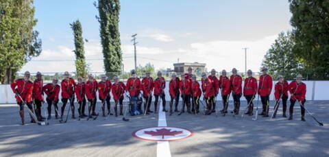 RCMP members wearing serge and holding hockey sticks