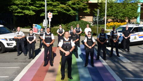 Several RCMP members standing on a Project Rainbow crosswalk