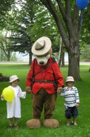 Photo of Safety Bear holding hand with two children in Connaught Hill Park