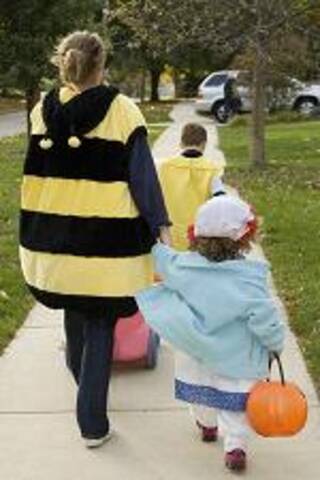 An adult with two kids in costumes