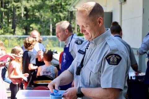 RCMP member holding a measuring cup and spoons